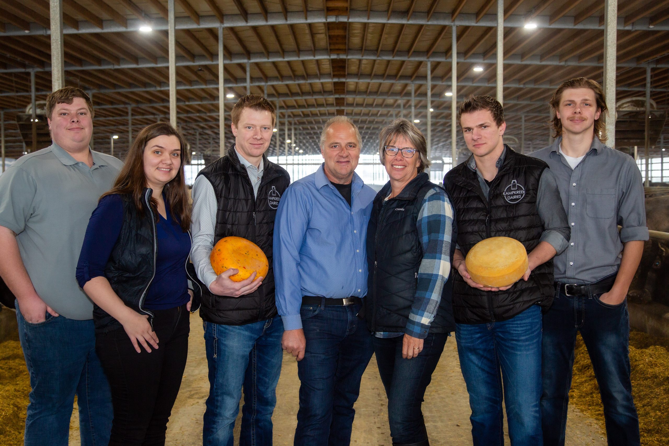 water buffalo dairy
Kampkreek Dairies family standing together inside the dairy barn, with two family members holding rounds of cheese